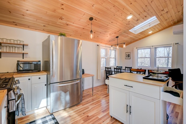 kitchen with butcher block counters, a wall mounted air conditioner, white cabinetry, wood ceiling, and appliances with stainless steel finishes