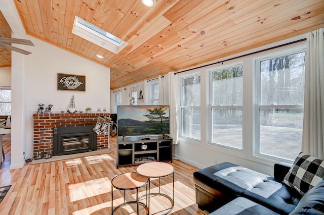 living area featuring plenty of natural light, a fireplace, wood finished floors, and wooden ceiling