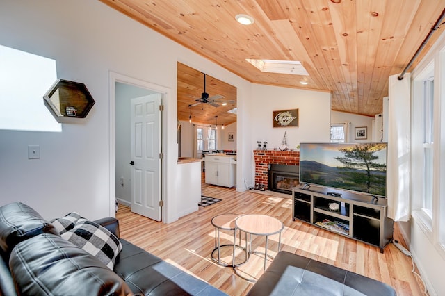 living room featuring light wood-style floors, wooden ceiling, and plenty of natural light