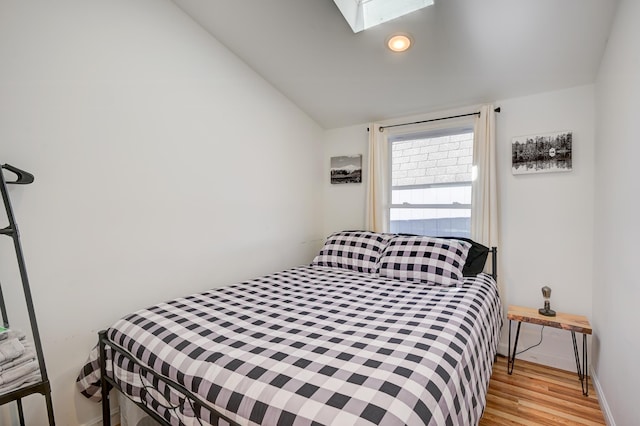 bedroom with recessed lighting, baseboards, wood finished floors, and lofted ceiling with skylight
