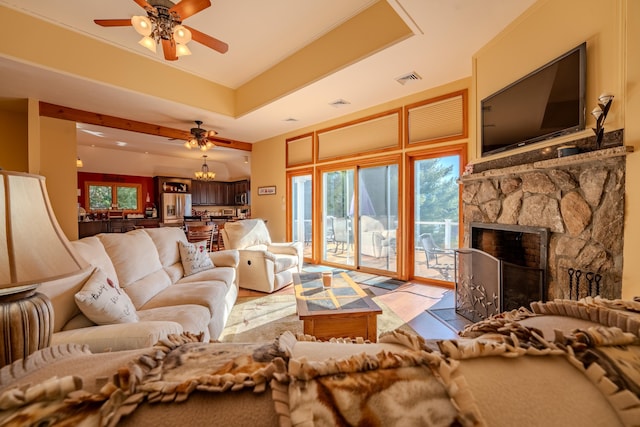 living room with visible vents, a ceiling fan, a healthy amount of sunlight, and a fireplace