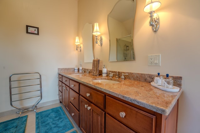 bathroom featuring a sink, baseboards, a shower, and double vanity