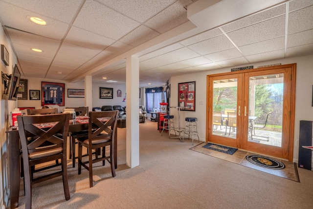 carpeted dining area featuring french doors, recessed lighting, and a paneled ceiling