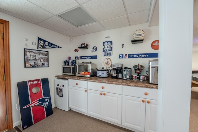 bar featuring carpet floors, stainless steel microwave, refrigerator, and a paneled ceiling