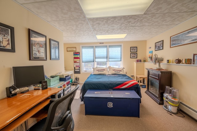 carpeted bedroom featuring a drop ceiling and a baseboard radiator