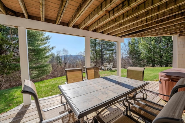 exterior space featuring a hot tub, a yard, and outdoor dining area