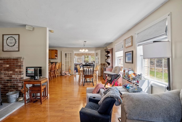 living area with light wood-type flooring and an inviting chandelier