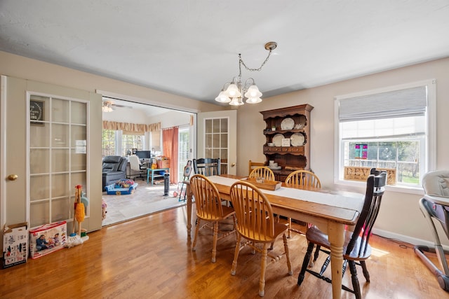 dining area featuring light wood-style flooring and a notable chandelier