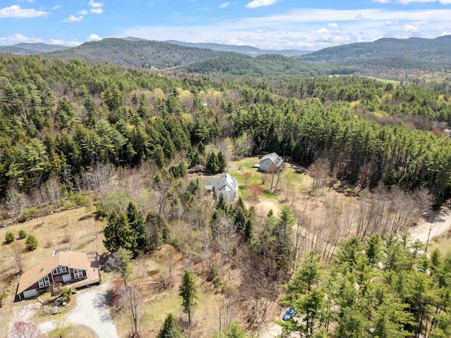 drone / aerial view featuring a wooded view and a mountain view