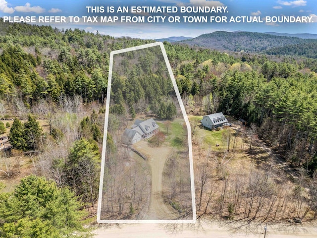 birds eye view of property with a mountain view and a forest view