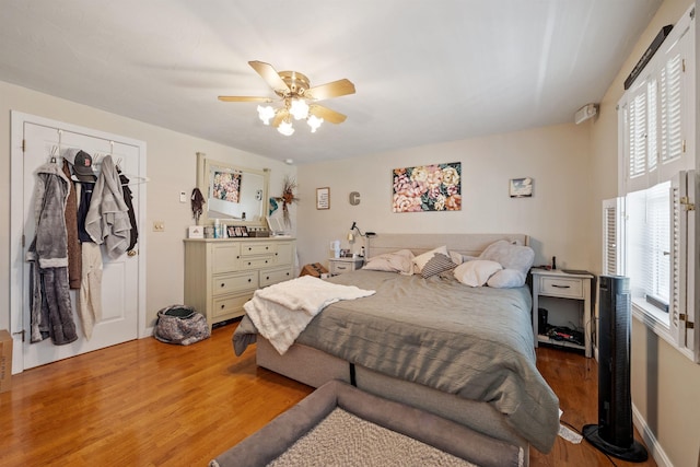 bedroom with baseboards, a ceiling fan, and light wood-type flooring