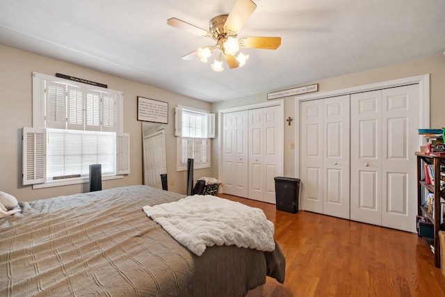 bedroom with multiple closets, ceiling fan, and wood finished floors