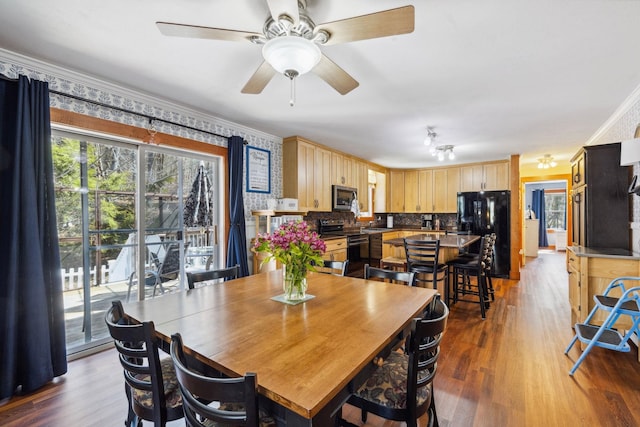dining space with crown molding, a ceiling fan, and wood finished floors