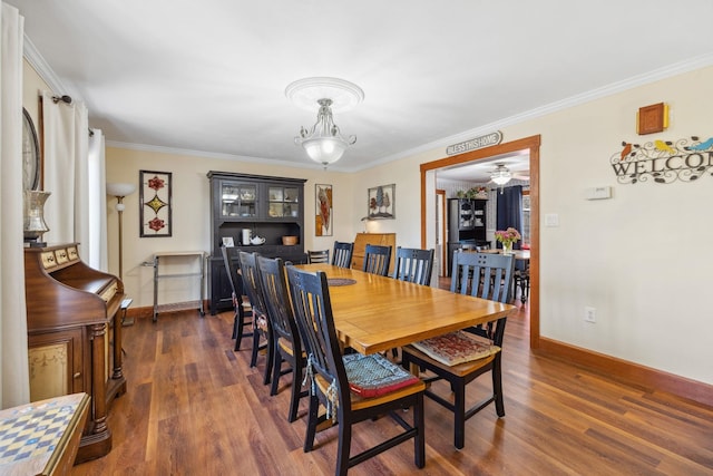 dining room with baseboards, ornamental molding, wood finished floors, and ceiling fan with notable chandelier