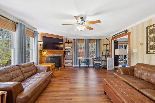 living area featuring a ceiling fan, wallpapered walls, plenty of natural light, and a fireplace