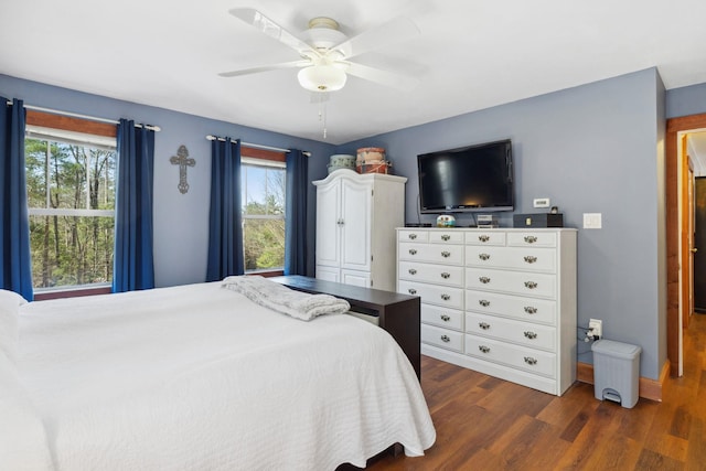 bedroom with dark wood-style flooring, ceiling fan, multiple windows, and baseboards