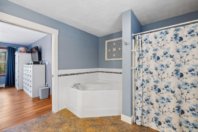 full bath with a wainscoted wall, a bath, a shower with curtain, and tile walls
