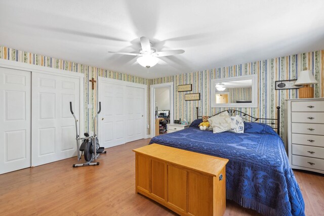 bedroom featuring a ceiling fan, wallpapered walls, and wood finished floors