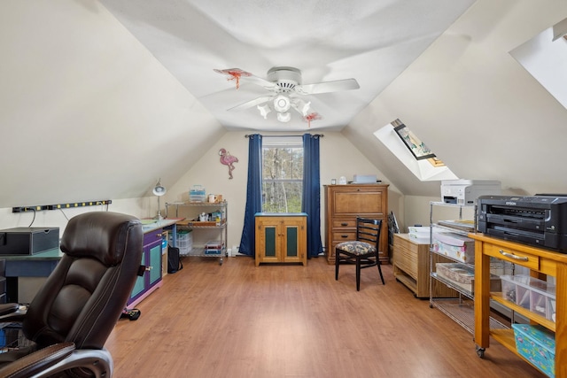 office with a ceiling fan, lofted ceiling with skylight, and wood finished floors