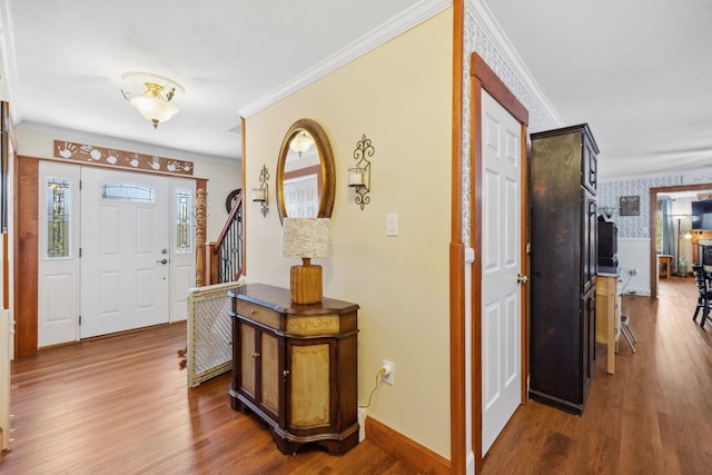 entrance foyer with crown molding, baseboards, and wood finished floors