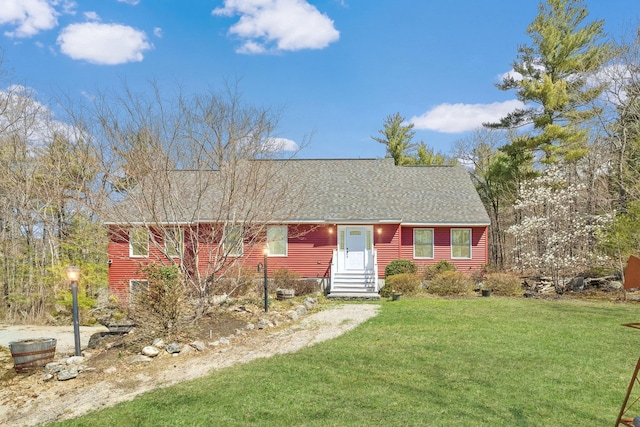 view of front of house featuring a shingled roof and a front lawn