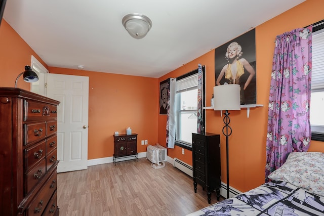 bedroom featuring baseboards, a baseboard radiator, and light wood-style flooring