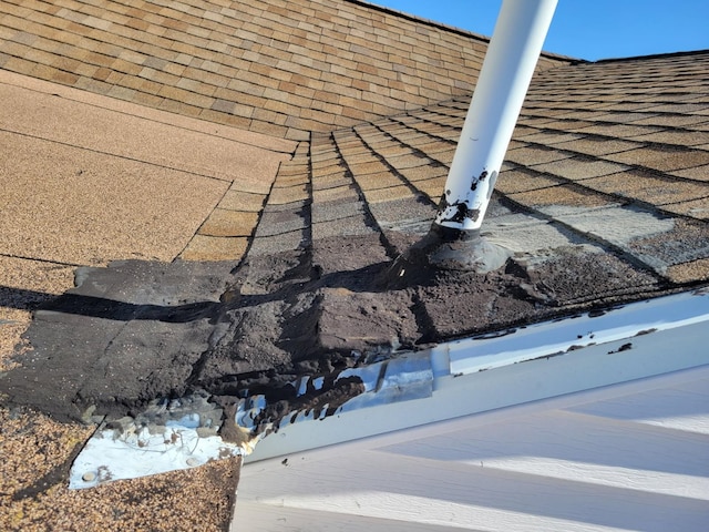 exterior details featuring roof with shingles