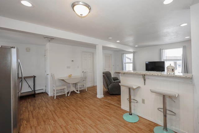 interior space featuring light wood-type flooring, freestanding refrigerator, and recessed lighting