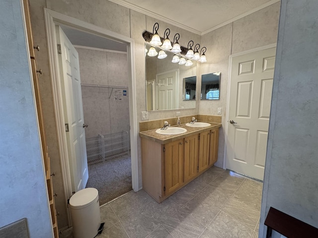 bathroom featuring crown molding, a sink, and double vanity