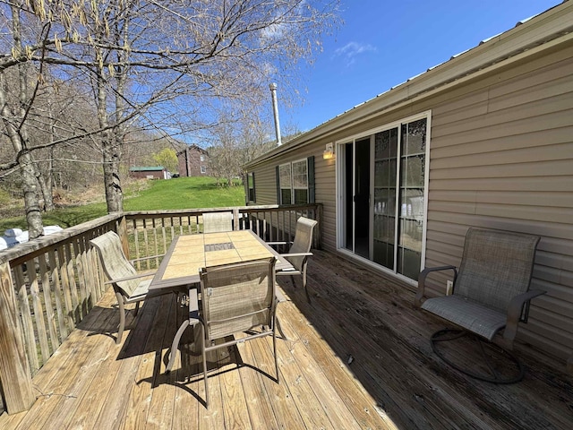 deck with a yard and outdoor dining space