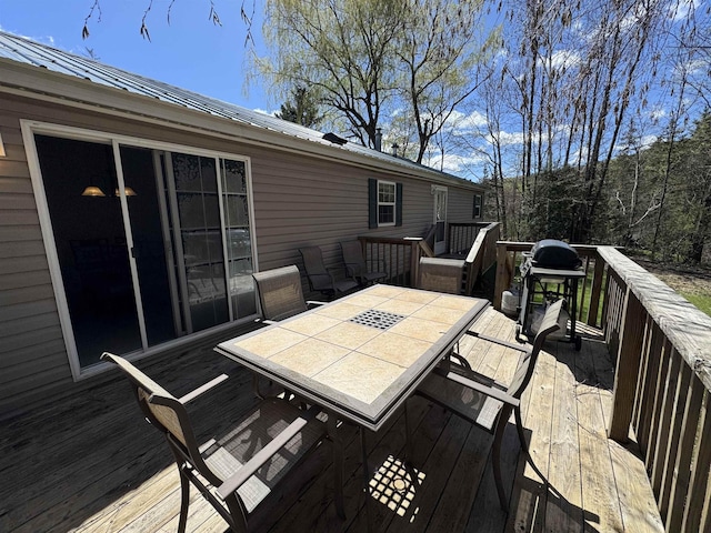 deck featuring outdoor dining area and a grill