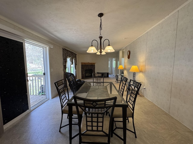 dining space with an inviting chandelier, a fireplace with raised hearth, and a textured ceiling