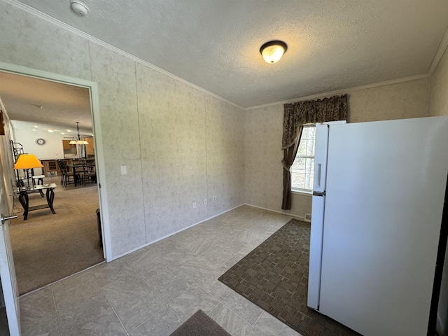 unfurnished dining area with ornamental molding and a textured ceiling
