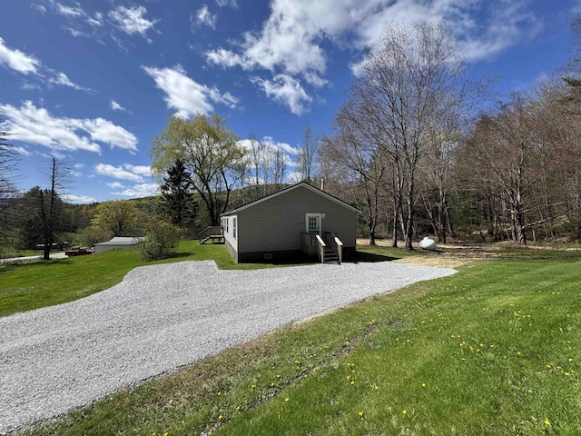 view of property exterior with a lawn and driveway