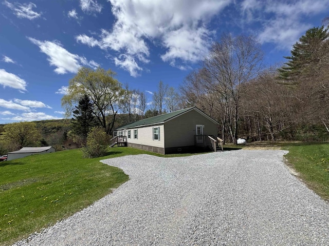 view of home's exterior with a lawn and gravel driveway