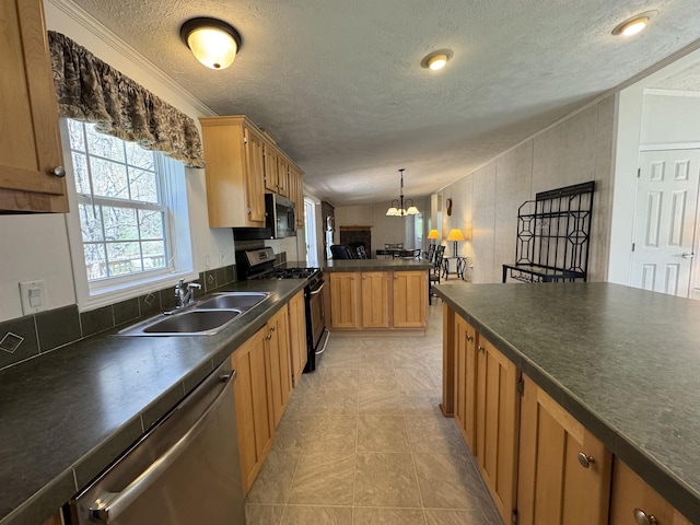 kitchen with a sink, dark countertops, stainless steel appliances, and a textured ceiling