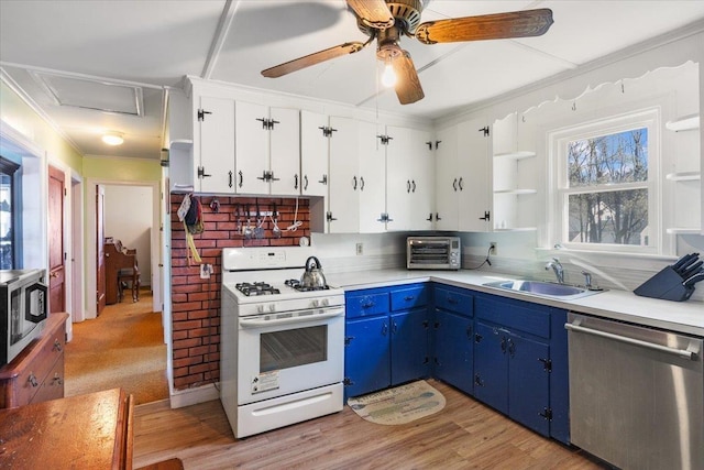 kitchen with crown molding, appliances with stainless steel finishes, a sink, light countertops, and blue cabinetry