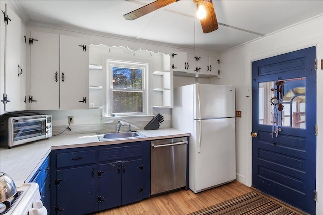kitchen with freestanding refrigerator, open shelves, blue cabinets, and dishwasher