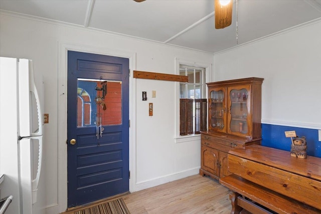 entrance foyer with baseboards, a ceiling fan, light wood finished floors, and ornamental molding