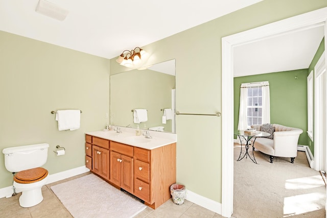 full bathroom with a sink, toilet, double vanity, tile patterned floors, and baseboards