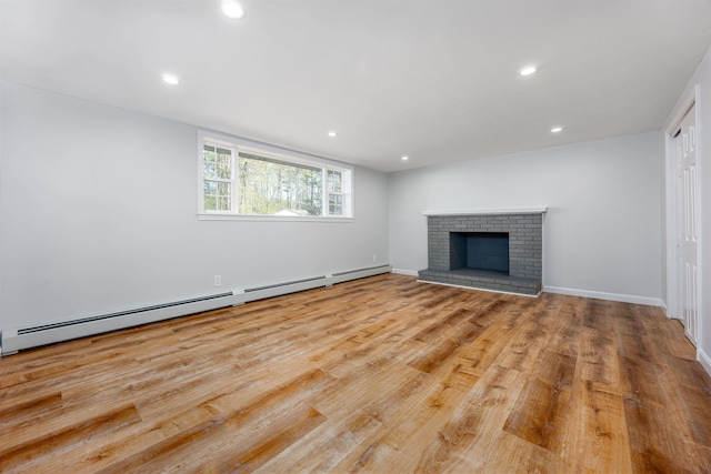 unfurnished living room with a brick fireplace, wood finished floors, baseboards, recessed lighting, and a baseboard heating unit