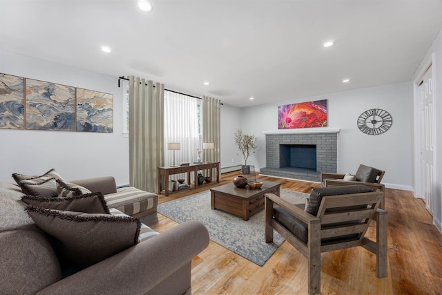 living room with baseboards, recessed lighting, a brick fireplace, and wood finished floors