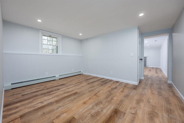 below grade area with recessed lighting, a baseboard radiator, and light wood finished floors
