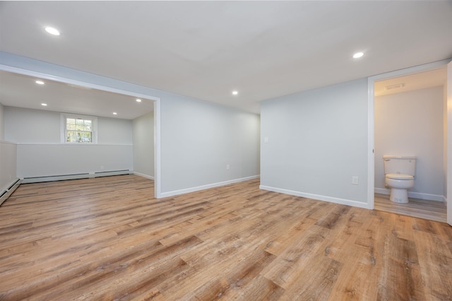 basement with baseboard heating, recessed lighting, baseboards, and light wood-style flooring