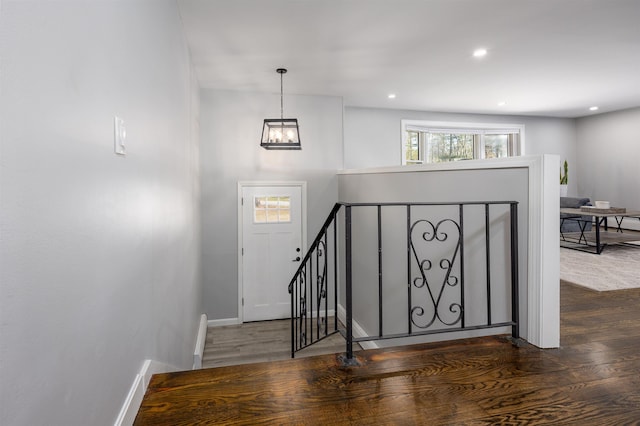 entrance foyer featuring baseboards, dark wood finished floors, and a notable chandelier