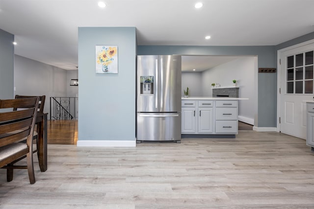 kitchen with stainless steel refrigerator with ice dispenser, baseboards, recessed lighting, and light wood finished floors
