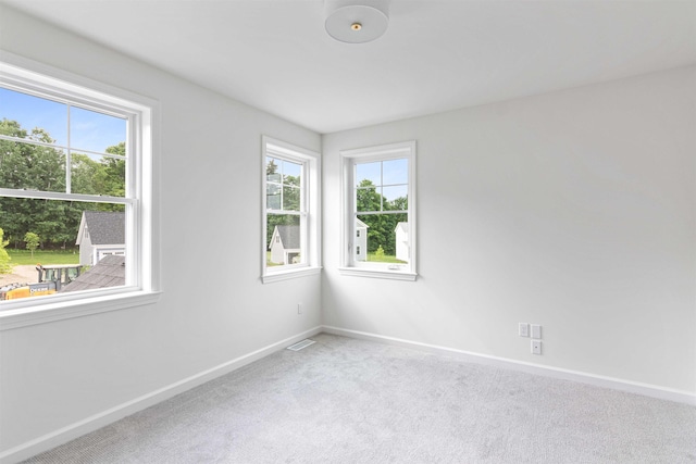 carpeted spare room with baseboards and visible vents