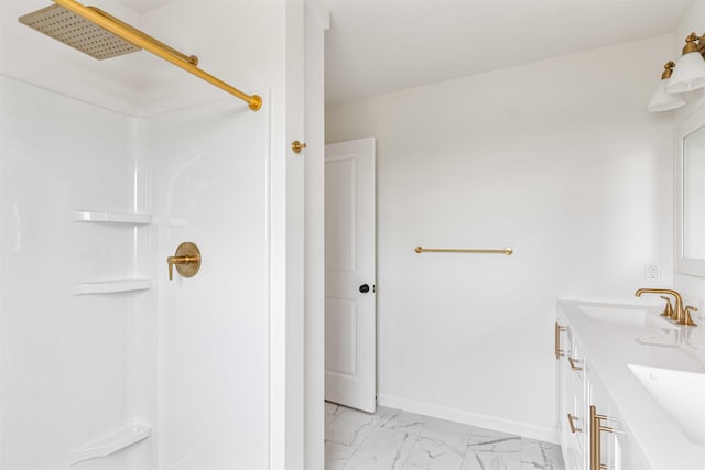 bathroom with a sink, a shower, and marble finish floor