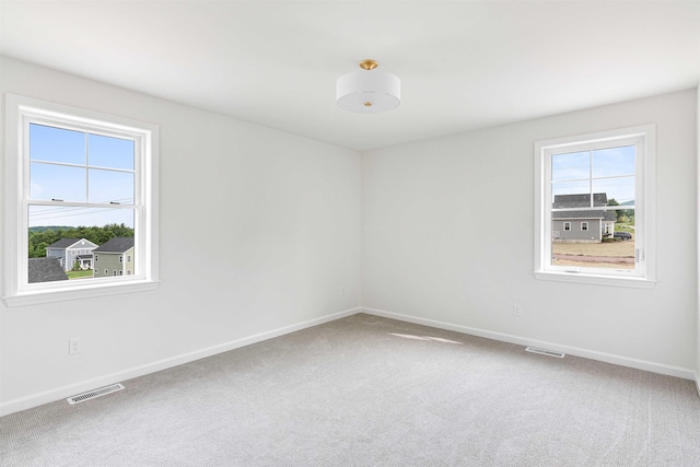 spare room featuring carpet floors, baseboards, and visible vents
