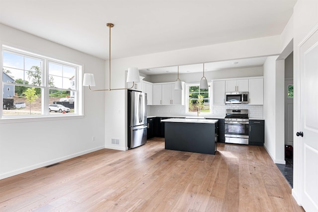 kitchen with visible vents, light countertops, appliances with stainless steel finishes, and tasteful backsplash
